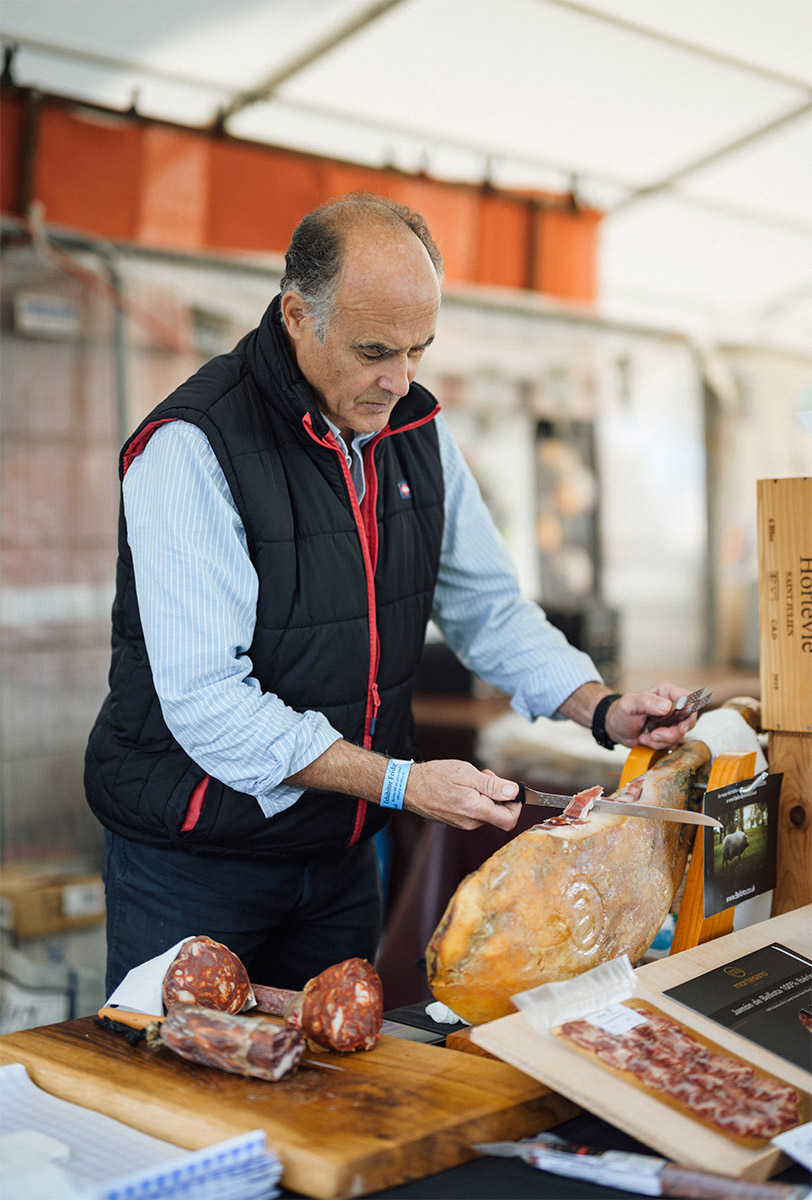 Producer slicing smoked meat at market in Ludlow | Visit Shropshire