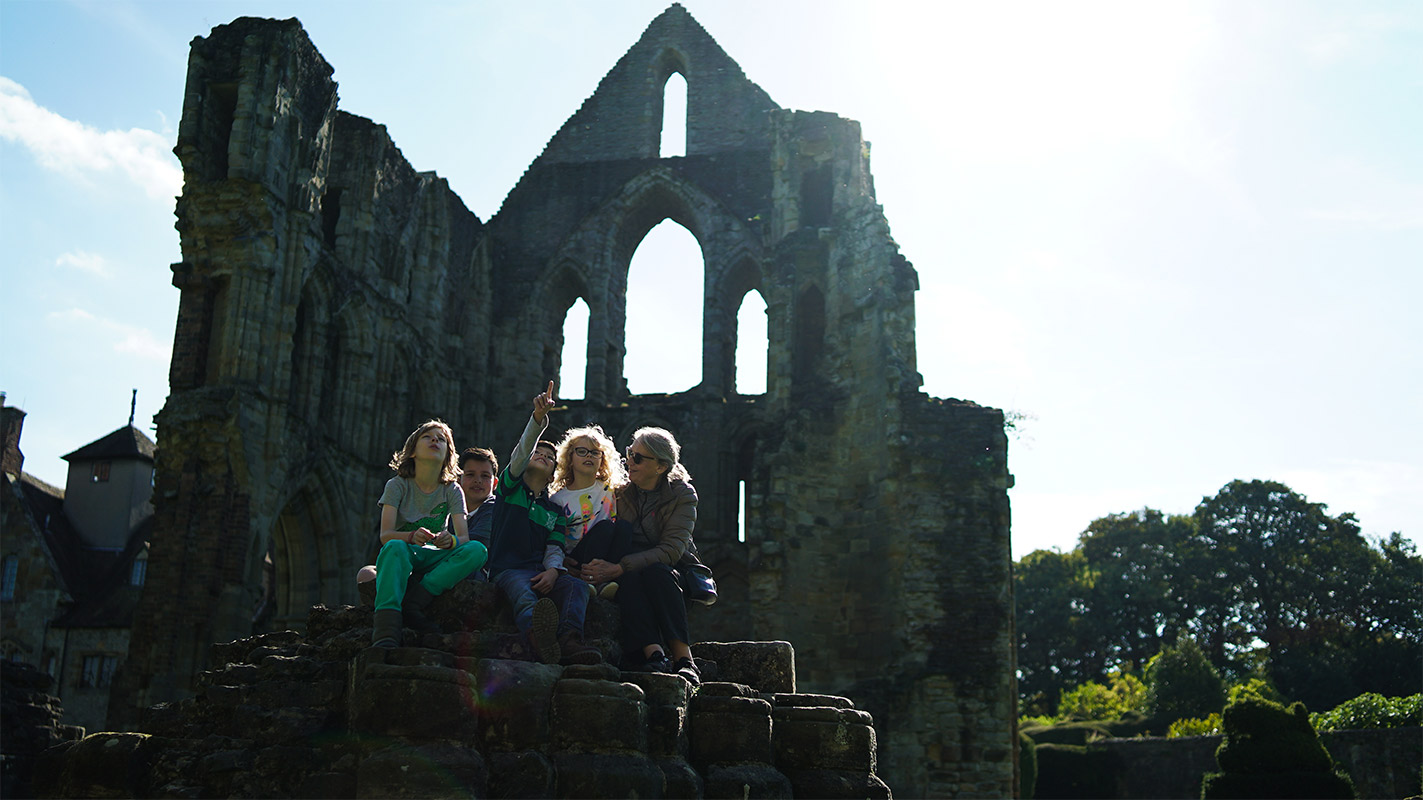 Family at church ruins Wenlock Priory | History | Visit Shropshire